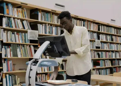 Gambar seseorang sedang scanning dokumen di aera perpustakaan